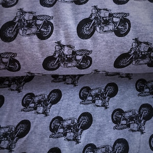 Könnte beinhalten: Ein grauer Stoff mit einem sich wiederholenden Muster aus schwarzen Motorrädern. Die Motorräder sind alle in die gleiche Richtung ausgerichtet und haben ein klassisches Design.