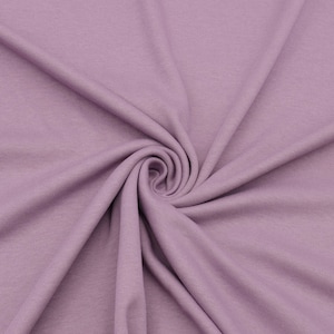 Könnte beinhalten: Eine Nahaufnahme eines weichen, glatten, lilafarbenen Stoffes. Der Stoff ist gefaltet und drapiert, wodurch seine Textur und Farbe sichtbar werden.
