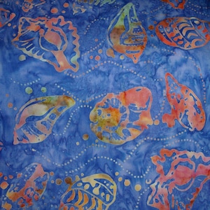 Op de afbeelding: Blauwe stof met een batikpatroon van schelpen in tinten oranje, roze en geel. De stof heeft een subtiel wit stippenpatroon.