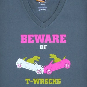 Beware of T-Wrecks (with Pink) - Funny T-Rex Dinosaur Crashing Cars Women's Charcoal Gray V-neck T-shirt // Funny Ladies Shirt