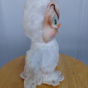 Puede incluir: Figura de b&uacute;ho de peluche blanco vintage con capucha. El b&uacute;ho tiene una cara pintada con ojos azules, un pico color melocot&oacute;n y mejillas rosadas. El b&uacute;ho est&aacute; sobre una superficie de madera.
