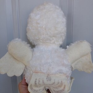 Puede incluir: Un juguete de p&aacute;jaro de peluche blanco vintage con alas y un cuerpo esponjoso. Las alas del p&aacute;jaro son de un tono blanco m&aacute;s claro, y el juguete parece ser muy querido. El juguete es un art&iacute;culo cl&aacute;sico para ni&ntilde;os.
