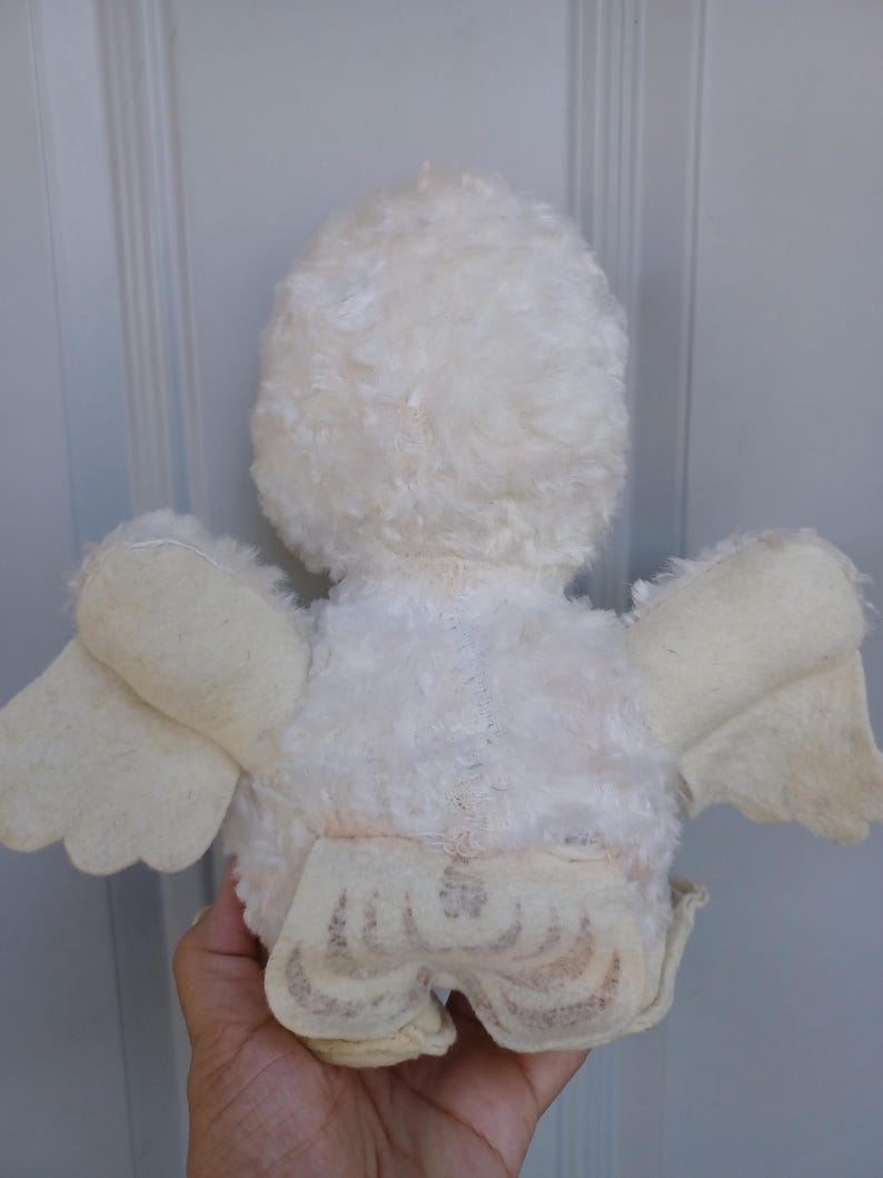 Puede incluir: Un juguete de p&aacute;jaro de peluche blanco vintage con alas y un cuerpo esponjoso. Las alas del p&aacute;jaro son de un tono blanco m&aacute;s claro, y el juguete parece ser muy querido. El juguete es un art&iacute;culo cl&aacute;sico para ni&ntilde;os.