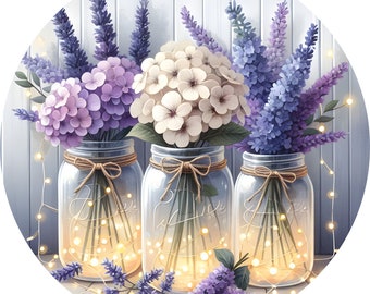 Puede incluir: Tres tarros de vidrio con flores de lavanda, blancas y moradas en su interior. Los tarros están atados con cuerda y tienen luces de hadas envueltas alrededor. Los tarros están sobre una superficie de madera blanca.