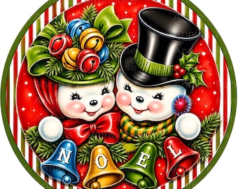 Puede incluir: Un letrero decorativo circular con dos caras de muñeco de nieve sonrientes sobre un fondo rojo con puntos blancos. Uno lleva un sombrero verde con campanas de colores, el otro un sombrero de copa negro. Cuatro campanas abajo forman NOEL.