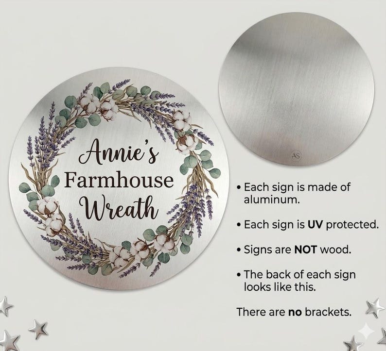 Puede incluir: Un letrero circular de aluminio con una corona impresa de ramas de lavanda, hojas de eucalipto y flores de algod&oacute;n. El texto central dice Annie's Farmhouse Wreath. Un segundo c&iacute;rculo m&aacute;s peque&ntilde;o muestra el reverso de metal cepillado.