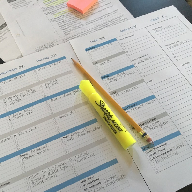 May include: A weekly planner with a yellow highlighter and a pencil. The planner has a blue and gray grid pattern with days of the week listed at the top. The planner is filled with handwritten to-do lists and assignments.