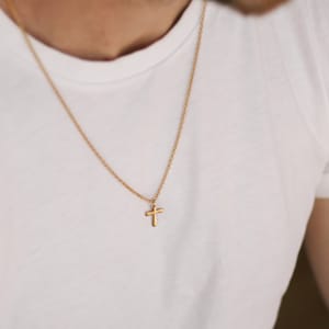 以下が含まれることがあります： 小さな金の十字架のペンダントが付いた金のチェーンネックレス