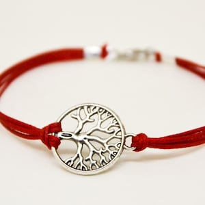 Puede incluir: Pulsera de cordón rojo con un dije plateado de árbol de la vida. La pulsera tiene un cierre de nudo corredizo ajustable. Una pieza de joyería sencilla y elegante.