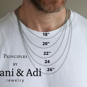 May include: A silver chain necklace in five different lengths: 18 inches, 20 inches, 22 inches, 24 inches, and 26 inches. The necklace is shown on a person's neck.