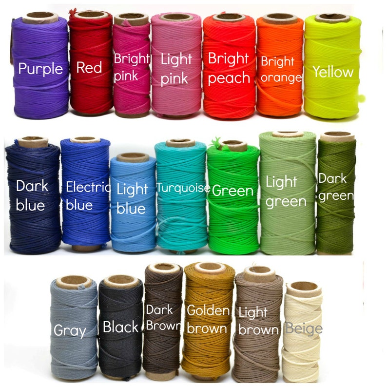 May include: A collection of spools of thread in various colors, including purple, red, pink, peach, orange, yellow, blue, turquoise, green, brown, gray, and beige. The spools are arranged in three rows of eight spools each.