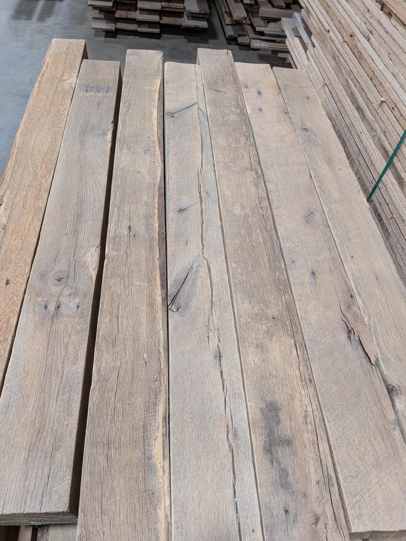 K&ouml;nnte beinhalten: Ein Stapel verwitterter, hellbrauner Holzbretter. Die Bretter haben ein nat&uuml;rliches, rustikales Aussehen mit sichtbarer Maserung und &Auml;sten. Das Holz scheint wiederverwertet oder gealtert zu sein, mit einer leicht rauen Textur.
