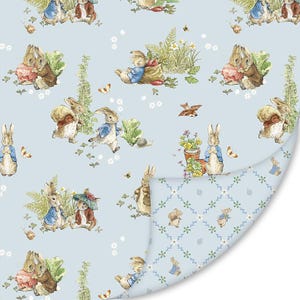 May include: A light blue fabric featuring a repeating pattern of Peter Rabbit characters in blue jackets, brown coats, and red accessories, interspersed with green plants, carrots, and butterflies. The reverse side shows a diamond lattice pattern.