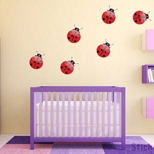 May include: A nursery room with a purple crib and shelves with a yellow wall decorated with red ladybug wall decals.