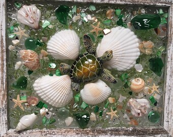 May include: A framed resin art piece featuring a green sea turtle surrounded by white seashells and green and iridescent glass pieces.