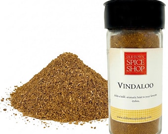 Può includere: Un barattolo di spezie Vindaloo di Old Town Spice Shop, accanto a un mucchio di spezie. Il barattolo ha un coperchio nero e un'etichetta con il nome della spezia e il logo del negozio. L'etichetta include anche il testo: "Aggiunge un calore audace e aromatico ai tuoi piatti preferiti."