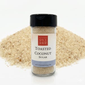 May include: A clear glass jar with a black lid, filled with toasted coconut sugar. The label reads "Old Town Spice Shop" and "Toasted Coconut Sugar." A pile of toasted coconut sugar is in the background. The website www.oldtownspiceshop.com is printed on the label.