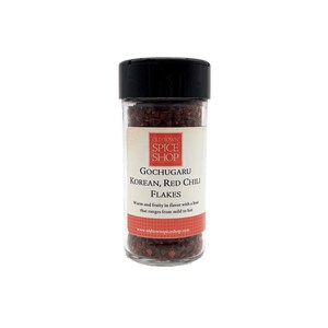 May include: A glass jar of red Korean Gochugaru chili flakes. The jar has a black lid and a white label with the text "Old World Spice Shop" and "Gochugaru Korean, Red Chili Flakes".