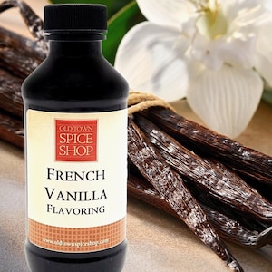May include: A dark brown plastic bottle with a black screw cap containing French Vanilla Flavoring. The label features a red square with the text Old Town Spice Shop and the words French Vanilla Flavoring in black text on a cream background.