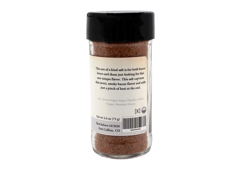 Puede incluir: Un tarro de vidrio con tapa negra lleno de condimento marr&oacute;n. La etiqueta dice "Esta sal &uacute;nica es para los amantes del tocino y para aquellos que buscan un nuevo sabor &uacute;nico. Esta sal captura el sabor dulce y ahumado del tocino y agrega un toque de picante al final." La etiqueta tambi&eacute;n enumera los ingredientes: Sal, Az&uacute;car moreno, Az&uacute;car, Piment&oacute;n, Ajo, Pimienta, Mostaza, Cebolla. El tarro est&aacute; etiquetado con un peso neto de 2,6 oz (72 g) y una fecha de caducidad del 10/2026. El tarro se fabrica en Fort Collins, CO.