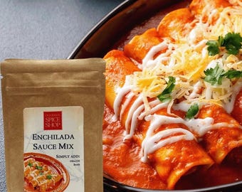 May include: A brown paper pouch of Old Town Spice Shop Enchilada Sauce Mix with a label showing a picture of enchiladas, text stating 16 Ounces Prepared and Net wt. 1.5 oz (42 g), placed next to a dark oval dish filled with red enchiladas topped with cheese.