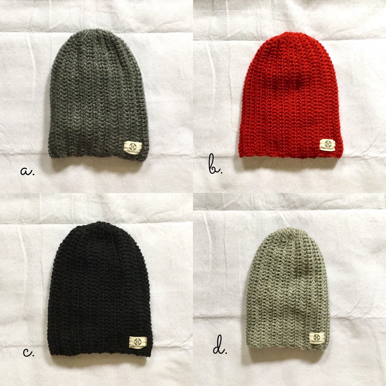 May include: Four knitted beanies in different colors: gray, red, black, and light gray. Each beanie has a small, white label with a logo on the side.