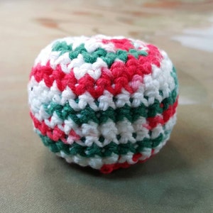 May include: A crocheted ball with red, white, and green stripes.