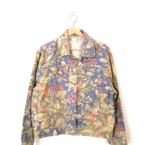 May include: A long-sleeved button-down jacket featuring a blue base colour with an all-over botanical print of green leaves, tan foliage, and clusters of small red berries. The jacket includes a pointed collar, two chest pockets, and buttons.