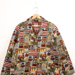 May include: A long-sleeve button-down jacket featuring a multi-coloured tapestry print of farm scenes, including roosters, cows, sheep, baskets of produce, and American flags. The jacket has a notched collar and two front patch pockets.