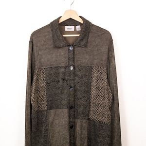 May include: A long-sleeved button-down shirt in shades of brown and black. The garment features a collared neckline and a patchwork design with alternating textured panels, including solid dark brown sections and woven black and brown patterns.