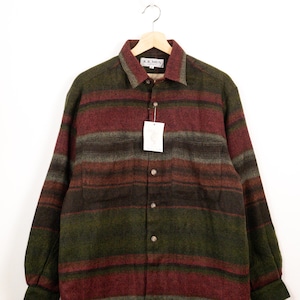 May include: A long-sleeve button-up shirt featuring a horizontal striped pattern in shades of dark green, burgundy, and charcoal grey. The shirt has a classic collar, two chest pockets, and a brand label reading K.K. MEN at the inner neckline.