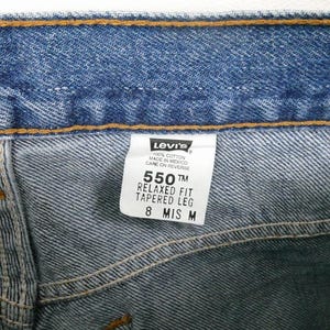 Może przedstawiać: Dżinsy z niebieskiego denimu z metką Levi's. Na metce widnieje napis "550 TM Relaxed Fit Tapered Leg 8 MIS M".