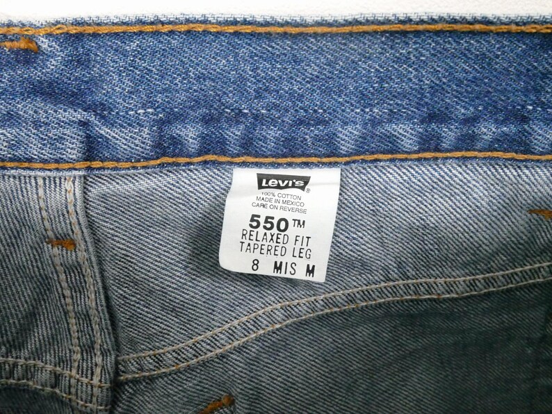 Może przedstawiać: Dżinsy z niebieskiego denimu z metką Levi's. Na metce widnieje napis "550 TM Relaxed Fit Tapered Leg 8 MIS M".