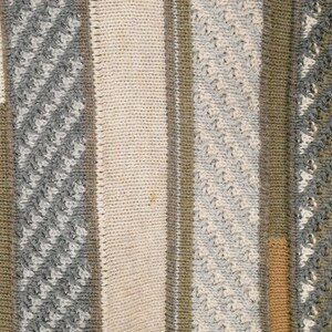 Puede incluir: Primer plano de un textil de punto con rayas verticales en varios colores y texturas. El dise&ntilde;o incluye secciones en crema, gris, verde oliva y beige. Algunas rayas tienen un punto texturizado y estampado.