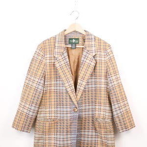 May include: A beige, blue, and white checked blazer with a single button and two front pockets. The jacket is suspended on a wooden hanger. The label reads "Hunt Club". The background is white.