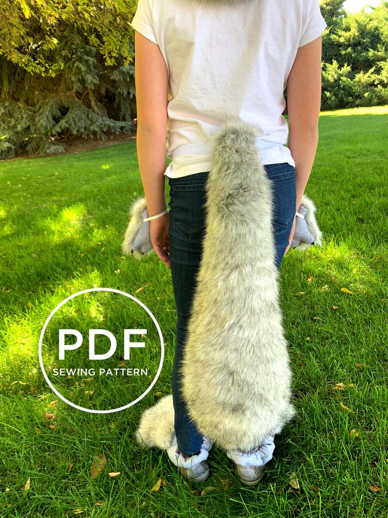 May include: PDF sewing pattern for a wolf tail costume. The tail is made of grey and white faux fur and is attached to a belt. The pattern includes instructions for making the tail and paws.