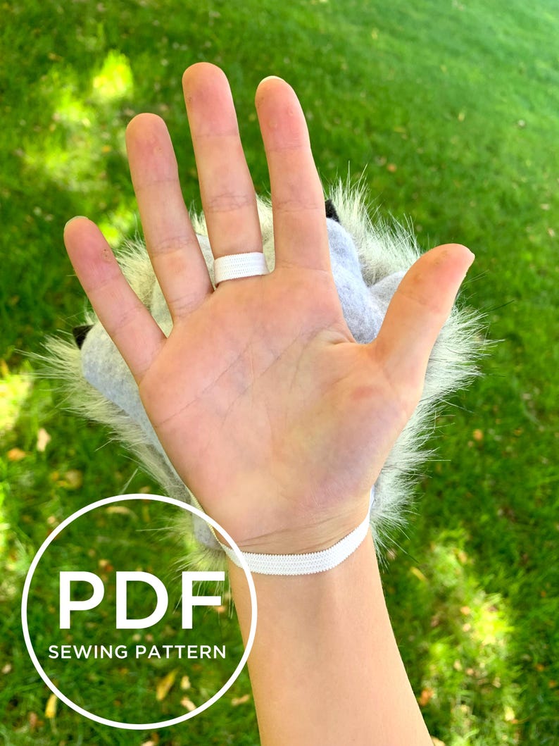 May include: A white furry hand puppet with a grey fabric palm and a white elastic wrist strap. The puppet is worn on a person's hand. The text "PDF SEWING PATTERN" is visible in the image.