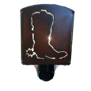 May include: A brown metal night light shaped like a cowboy boot with a gold outline. The boot has a spur on the heel.