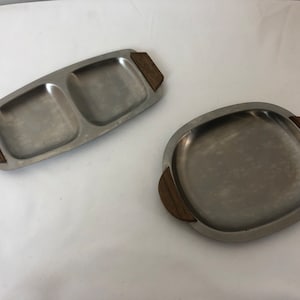 May include: Two stainless steel serving trays with wooden handles. The larger tray is divided into two sections.