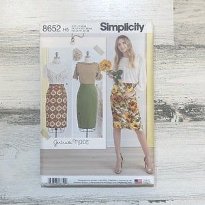 Op de afbeelding: Een naaipatroon voor een rok, Simplicity patroon nummer 8652, maat US 6-14, EU 32-40, Frans 34-42. Het patroon toont drie verschillende rokstijlen, een met een bloemenprint, een met een geometrische print en een in effen groen. Het patroon is gelabeld "Gertrude Made".