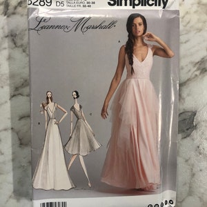 May include: A Simplicity sewing pattern for a dress, pattern number 8289, size US 4-12, size Euro 30-38, size FR 32-40. The pattern features a pink dress with a ruffled skirt and a white dress with a long skirt.