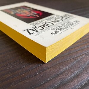 Pu&ograve; includere: Un libro tascabile giallo con il titolo "Baron Orgaz" e il testo "A New Traditional Novel" stampato sulla copertina.
