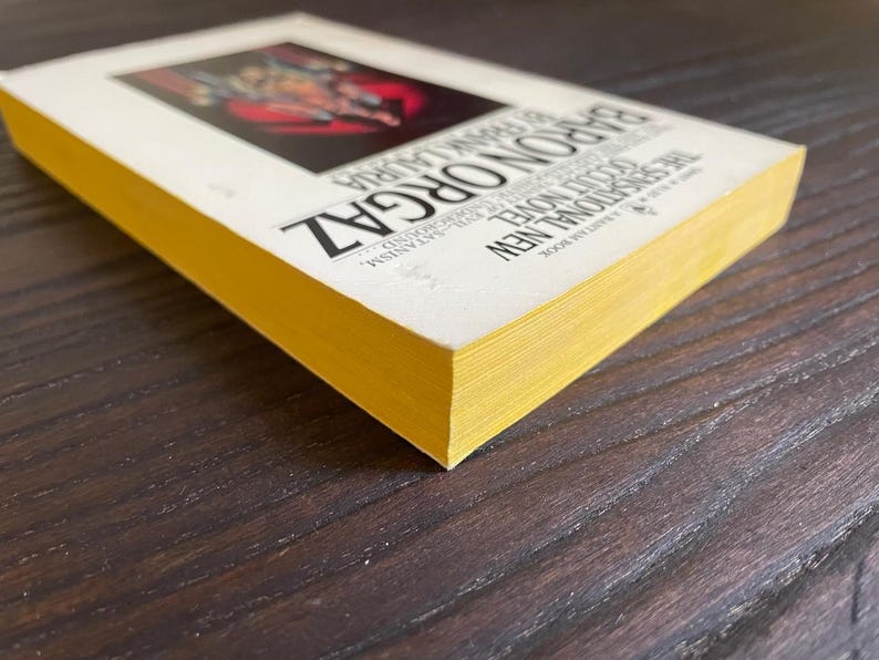 Pu&ograve; includere: Un libro tascabile giallo con il titolo "Baron Orgaz" e il testo "A New Traditional Novel" stampato sulla copertina.