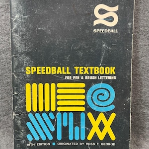 May include: A vintage Speedball Textbook for pen and brush lettering. The cover is black with yellow and blue geometric designs. The title "Speedball Textbook" is in yellow, and the edition is the 19th.
