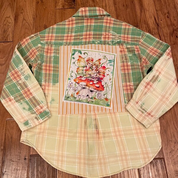 Vintage flannel, bleach washed, long sleeve button down shirt with a fairy panel sewn on the back.