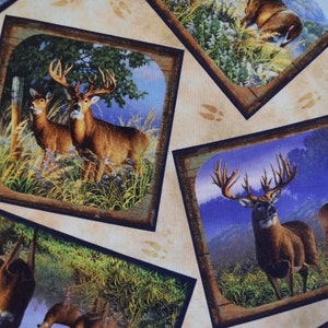 May include: Fabric with a repeating pattern of framed images featuring deer in a natural setting. The deer have large antlers and are set against a backdrop of trees, grass, and a blue sky. The fabric has a tan background.