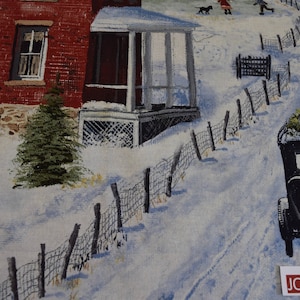 May include: A winter scene fabric panel depicting a snowy road leading past a red brick house and a small porch. A vintage black car carries a Christmas tree, and figures walk in the distance. A fence lines the road.