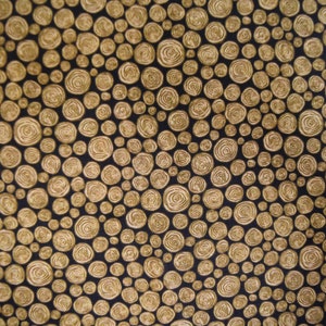 May include: A black fabric with a repeating pattern of gold circles. The circles are arranged in a random pattern and have a slightly raised texture.