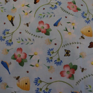 May include: Light blue fabric with a repeating pattern of flowers, bees, butterflies, and birds. The flowers are pink, white, and blue, with green leaves and stems. The bees and butterflies are yellow and brown. The birds are yellow and blue.