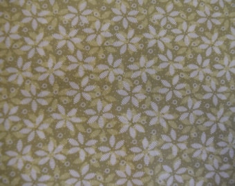 May include: A close-up of a fabric with a repeating pattern of white stylized flowers on a light green background.
